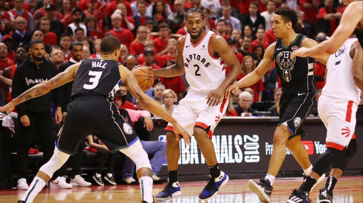Raptors forward Kawhi Leonard watches for the double-team trap by Bucks guards George Hill and Malcolm Brogdon during Game 6.