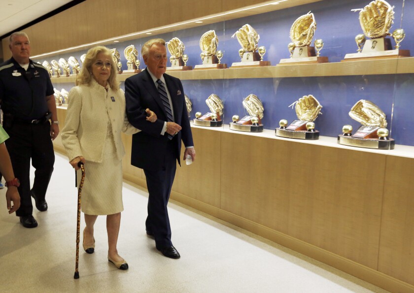 Dodgers Hall of Fame broadcaster Vin Scully and his wife, Sandi, walk past a display of Dodgers awards.