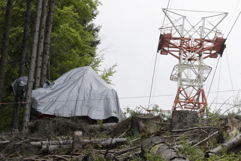 The wreckage of a cable car after it collapsed near the summit of the Stresa-Mottarone line in the Piedmont region, northern Italy, Wednesday, May 26, 2021. Police have made three arrests in the cable car disaster that killed 14 people after an investigation showed a clamp, placed on the brake as a patchwork repair effort, prevented the brake from engaging after the lead cable snapped. (AP Photo/Luca Bruno)