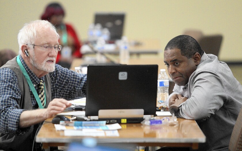 Mike Everding, left, a certified health insurance agent for Covered California, helps James Randle, 53, get a better health insurance rate at an Obamacare enrollment event at Faithful Central Bible Church in Inglewood in March.