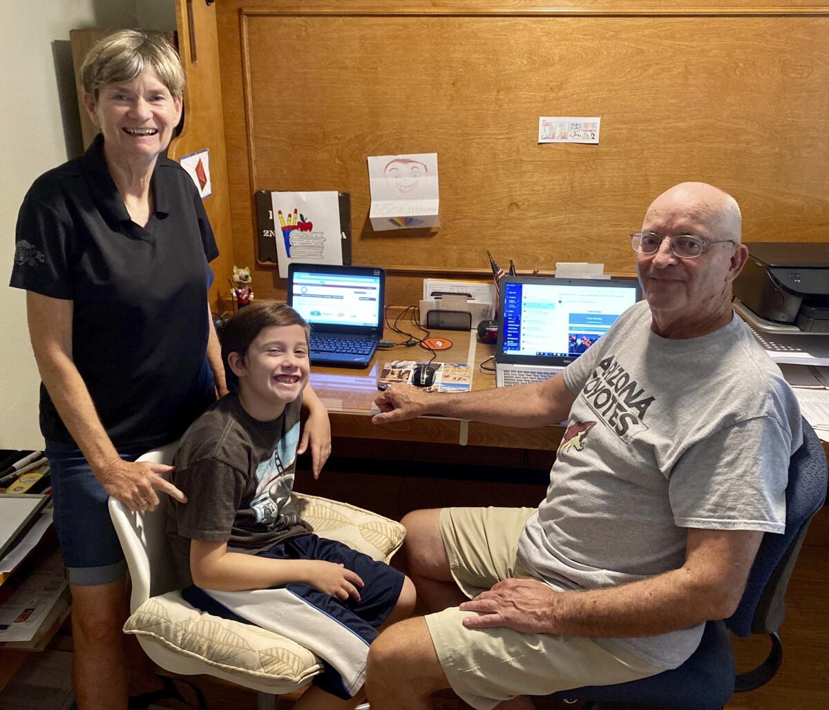 Bill and Mary Hill at their computer desk with their 8-year-old grandson, Will.