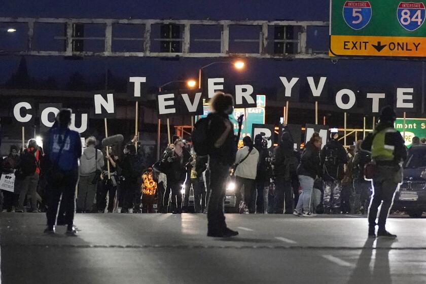 Protesters hold letters that spell Count Every Vote as they cross an overpass while marching in Portland, 