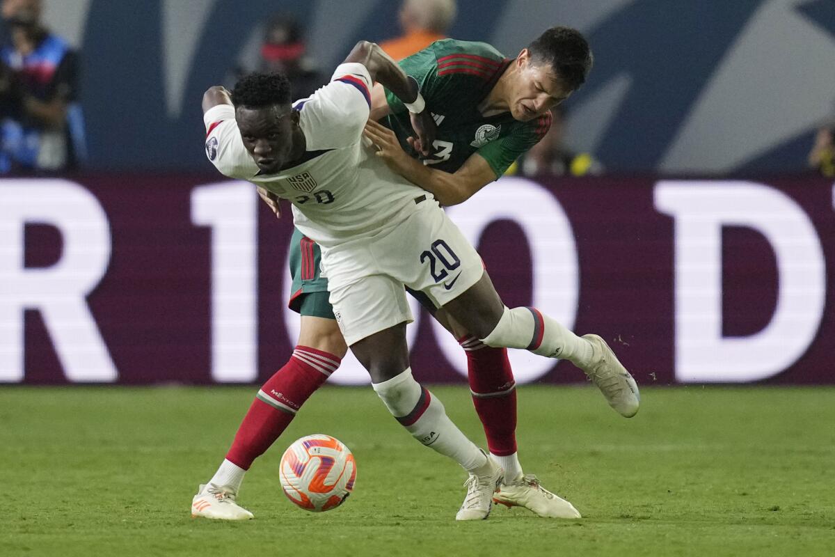 United States' Folarin Balogun battles for the ball with Mexico's Cesar Montes.