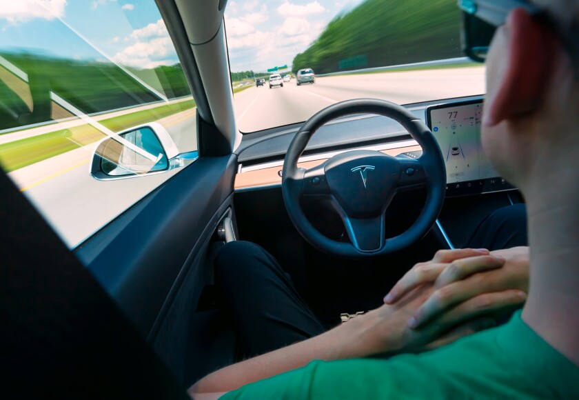 Driver folds hands as Autopilot drives the Tesla