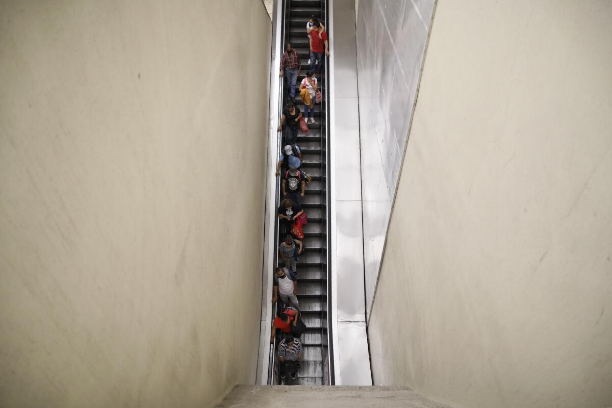 Usuarios bajando por una escalera mecánica en la parada Santa Anita del metro de la Ciudad de México. 