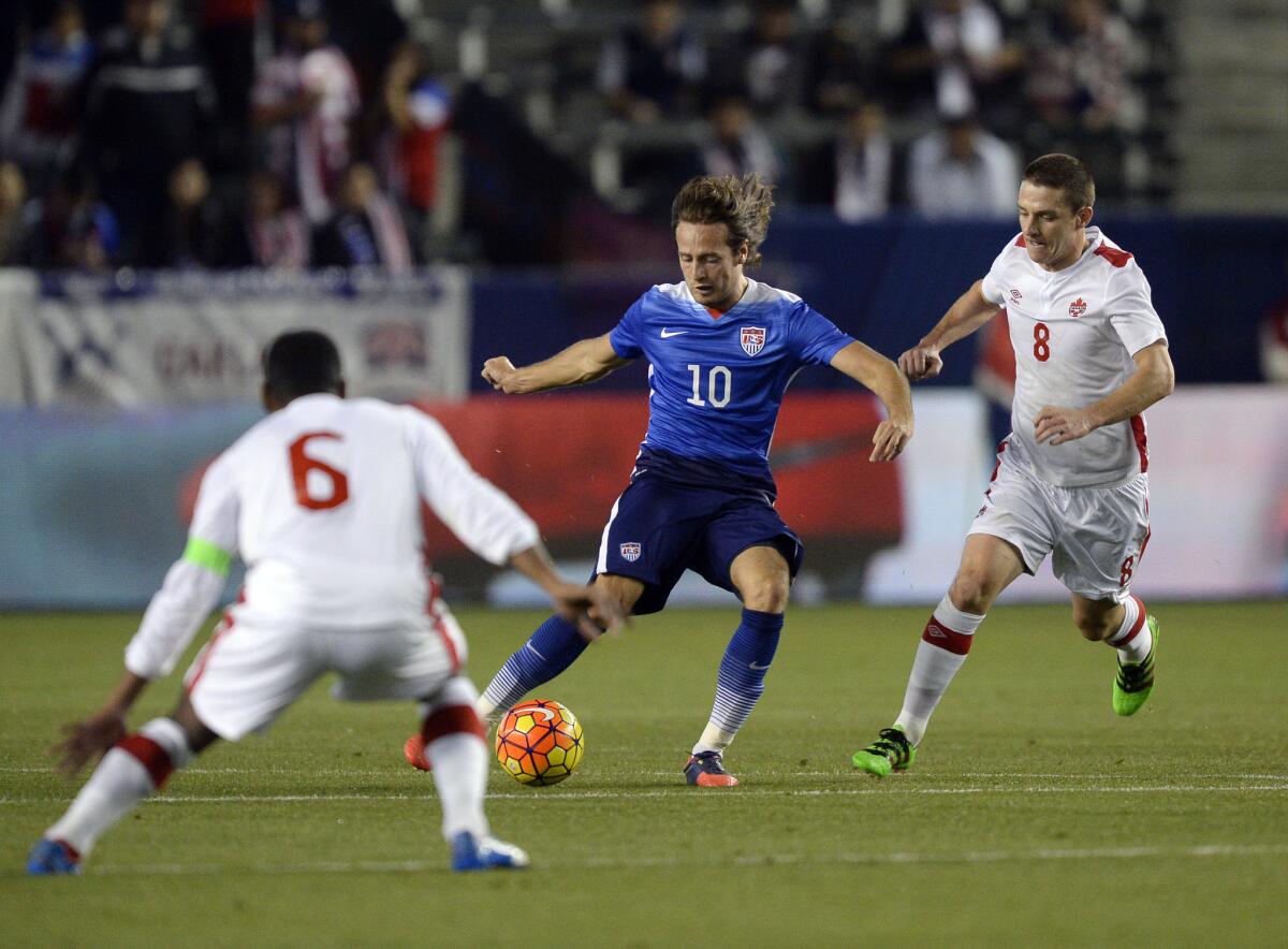Mix Diskerud of the U.S. controls the ball under pressure from Canada's Will Johnson and Julian de Guzman during a friendly at StubHub Center in Carson on Feb. 5.