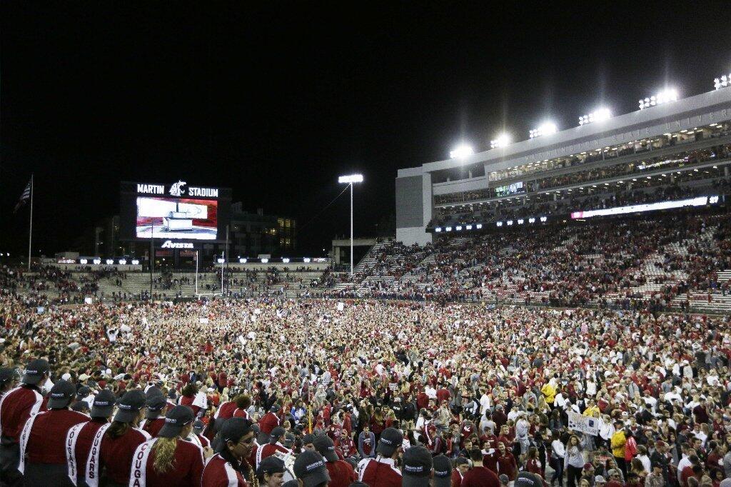 Washington State fans swarm the field after the Cougars' 30-27 victory over USC at Martin Stadium on Sept. 29.