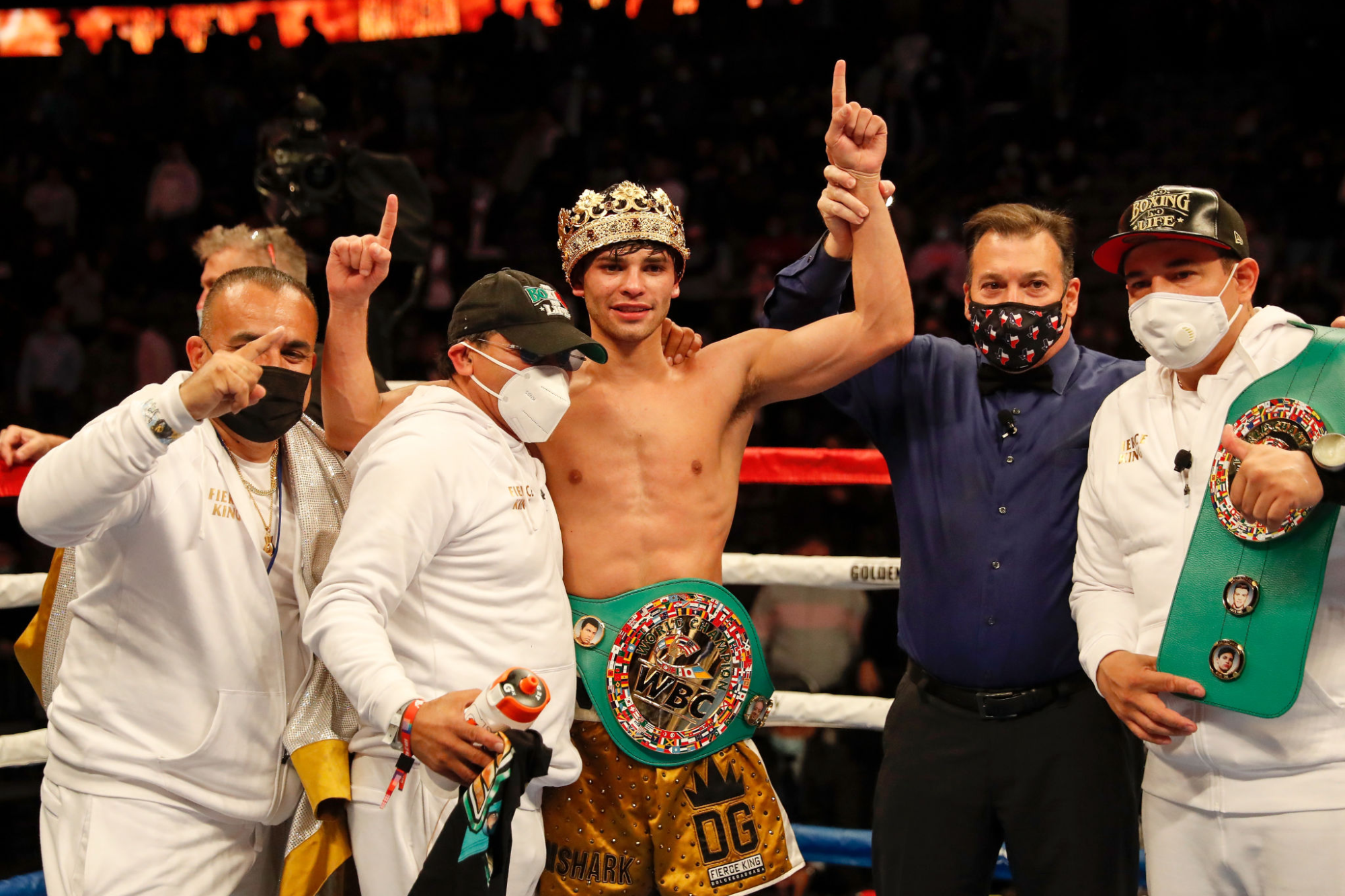 In the ring, Ryan Garcia smiles and raises in arms in victory after defeating Luke Campbell in a WBC title fight