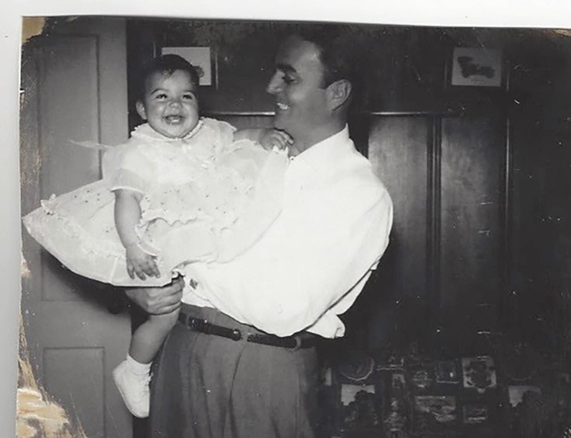 Hank Caruso holds his daughter Christina Caruso in the early 1960s inside their home.