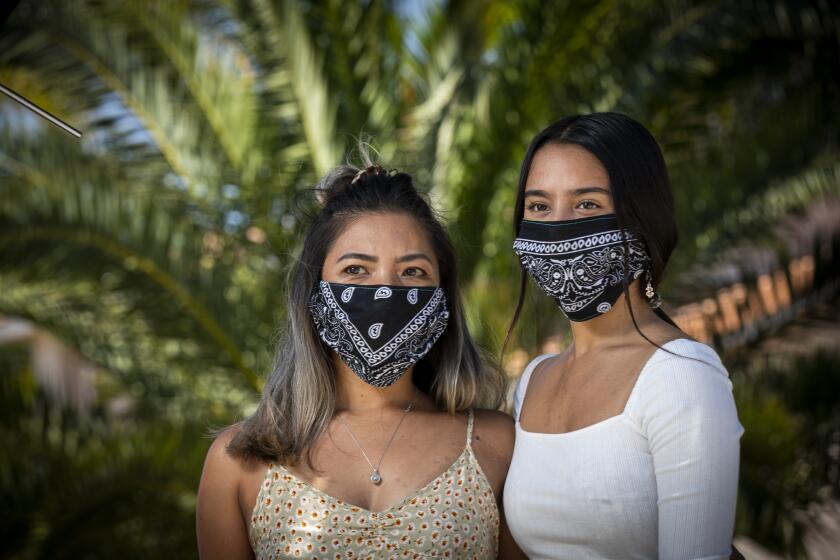 RIVERSIDE COUNTY, CA - JULY 02: Donalene Ferrer, left, who is of Filipino ancestry, and her daughter, Charlie, 17, who is Filipino-Italian are photographed wearing protective masks near their home in Riverside County. In April, they were walking with Donalene's mother in Oceanside when the mother's neighbor yelled at them from her car, saying: "You started the corona." There has been an increase in hate incidents against Asians and Asian Americans, with their accusers unleashing accusations at people they blame for infecting "Americans" with COVID-19. Photos taken Thursday, July 2, 2020 in Riverside County, CA. (Allen J. Schaben / Los Angeles Times)