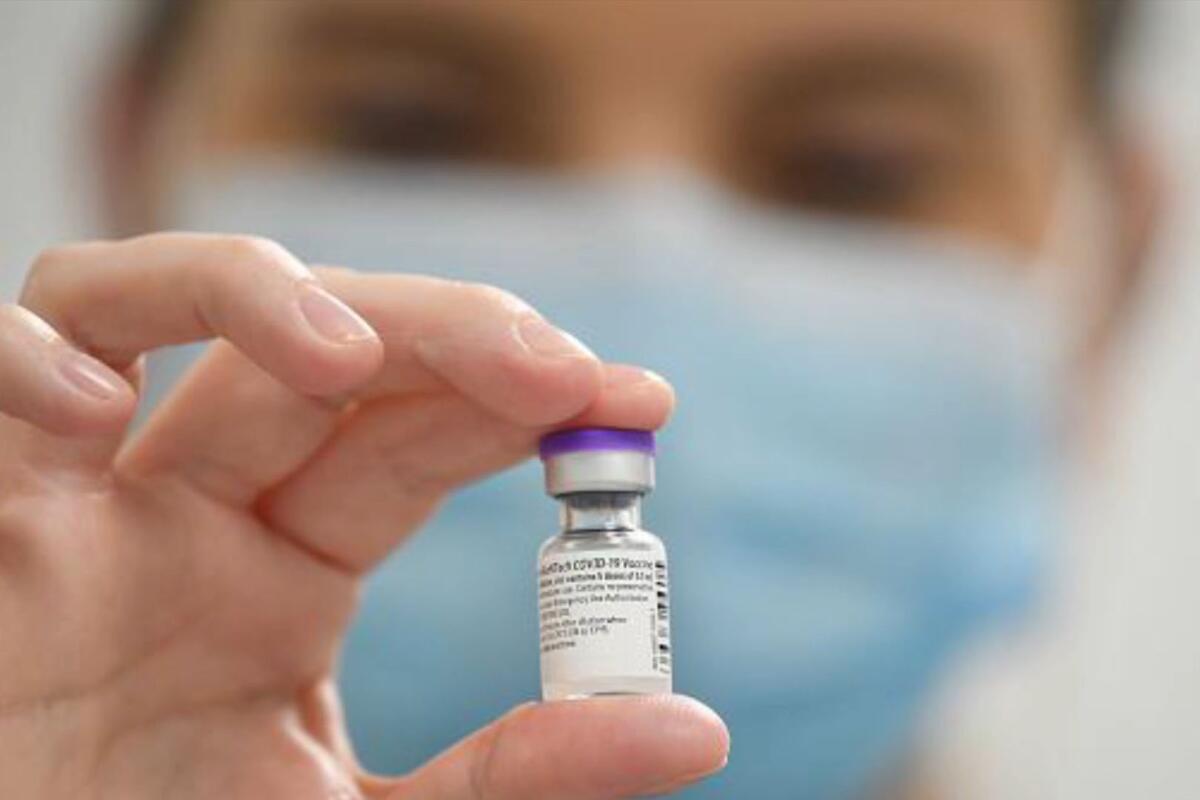 Closeup of a hand holding a vial of COVID-19 vaccine 