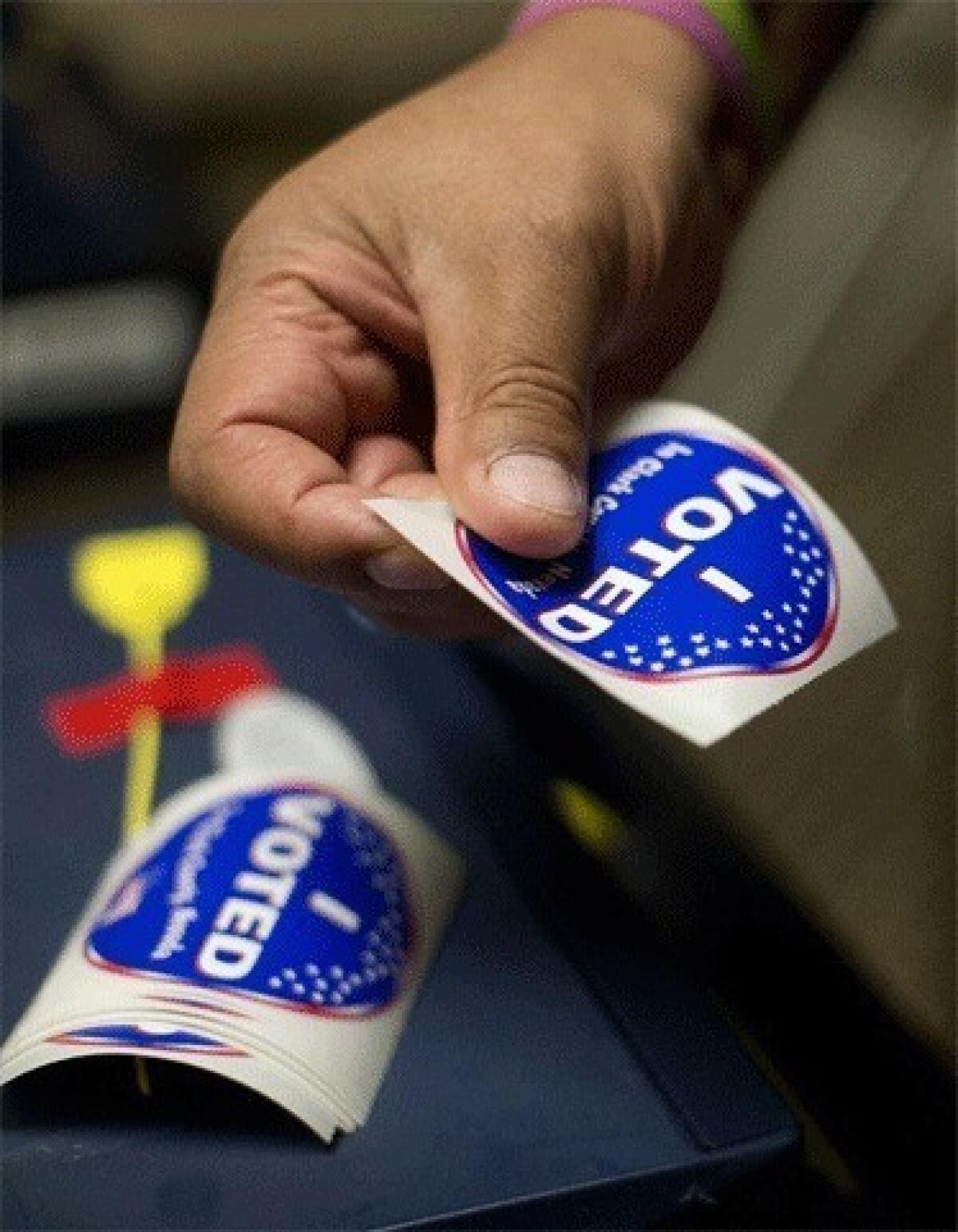 An election worker prepares voting stickers to hand out to voters in Las Vegas, Nev., where early voting in Nevada began on Oct. 20.