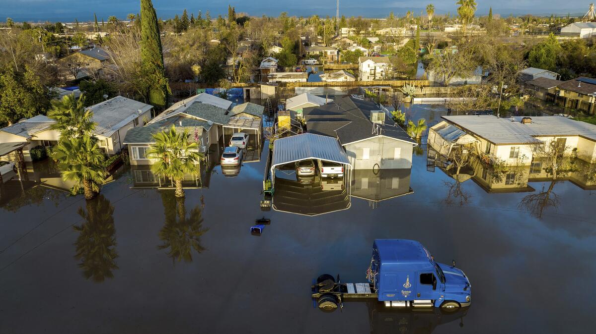 Water surrounds homes and vehicles.