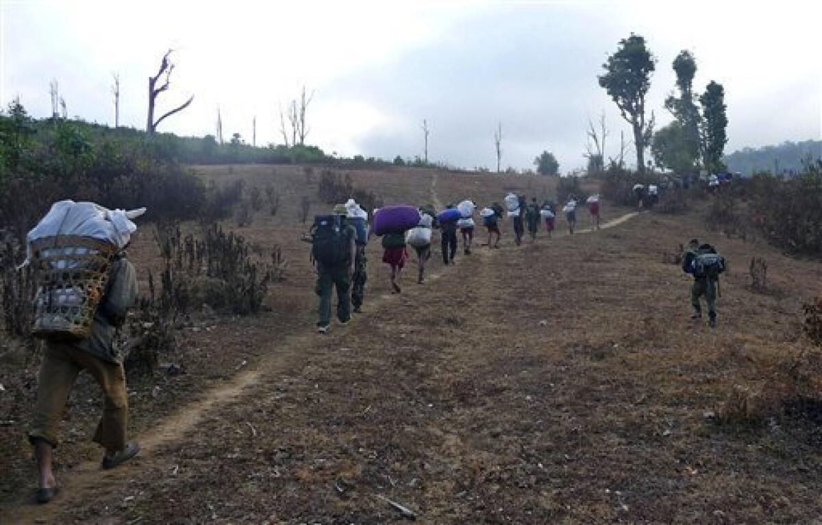 In this Friday, Jan. 8, 2010 picture released by the Free Burma Rangers, Karen villagers carrying relief supplies walk on a path as they flee Myanmar soldiers in Karen State, Myanmar. Half a million Karen tribespeople have been driven from their homes by the Myanmar military. The country's second largest ethnic minority, the Karens are about 4 million within Myanmar's 43 million. The vice president of the Karen National Union, the insurgency's political organization, says that colonial Britain broke its promise to carve out a separate state for the minority before granting Burma independence in 1949. (AP Photo/Free Burma Rangers)