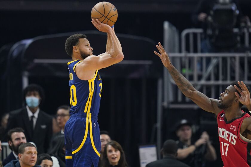 El base de los Warriors de Golden State Stephen Curry lanza un triple sobre el alero de los Rockets de Houston Tari Eason en el encuentro del sábado 3 de diciembre del 2022. (AP Foto/Godofredo A. Vásquez)