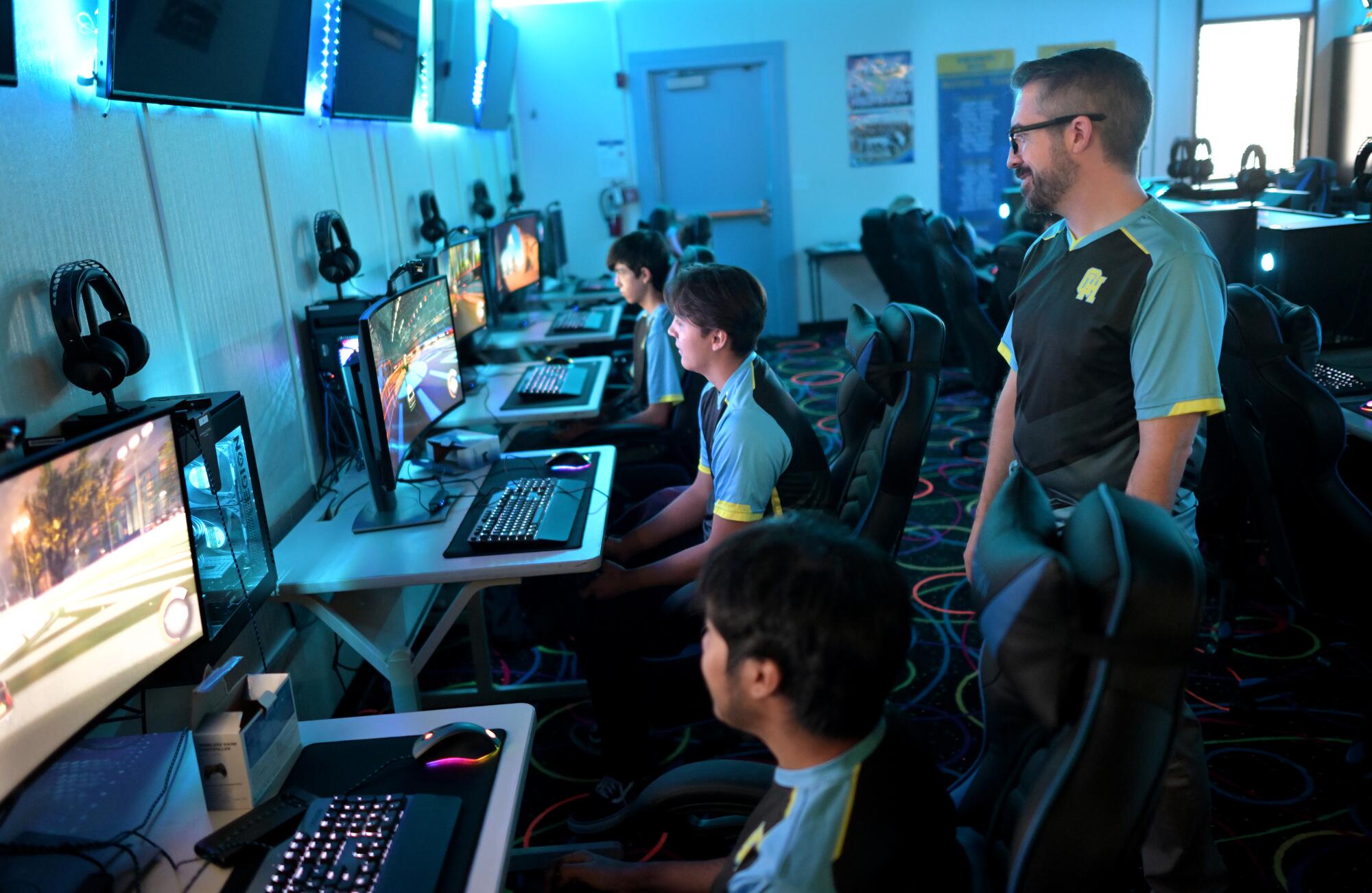 Esports players compete as coach Tim Fields looks on at Quartz Hill High School.