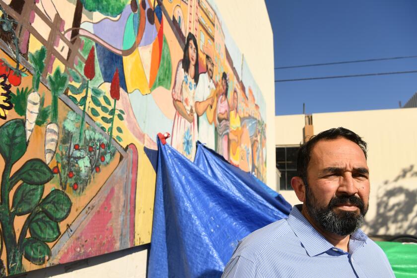 SANTA ANA, CALIFORNIA FEBRUARY 26, 2021-Volunteer Ben Vasquez stands outside the El Centro Cultural de Mexico in Santa Ana. The center is a nonprofit that is closed down because of the pandemic and is now a homeless camp. (Wally Skalij/Los Angeles Times)
