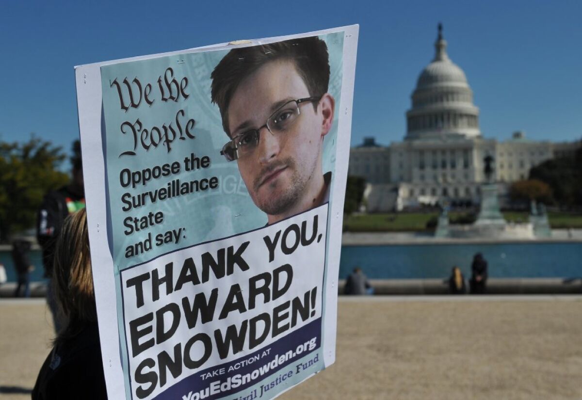 Demonstrators are seen holding placards supporting former U.S. intelligence analyst Edward Snowden.