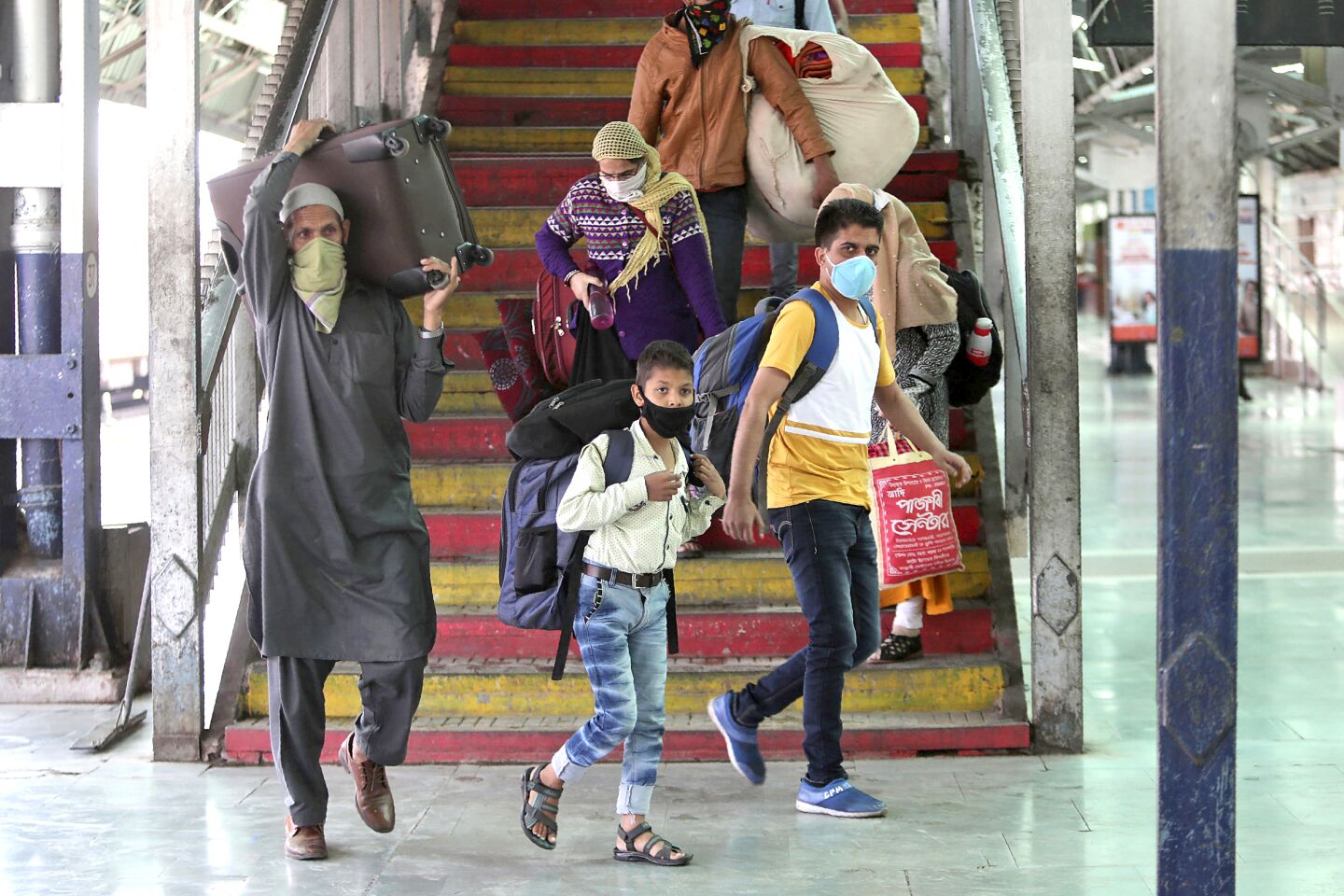 Inida: Indian commuters wearing masks arrive at a railway station in Jammu, India.