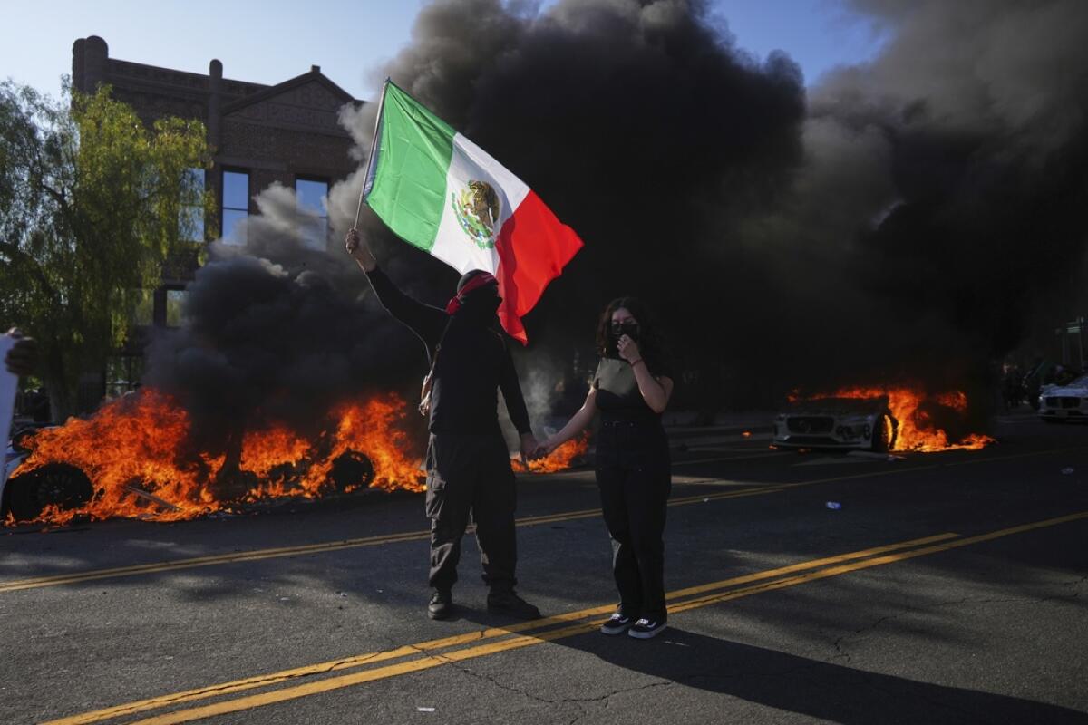 Un manifestante tiene una bandera mexicana