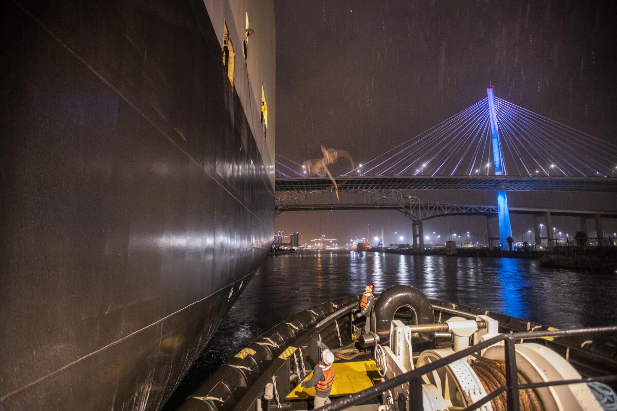  Max Cota and Charlie May reset their lines as the Marjorie C floats toward a lighted up bridge. 