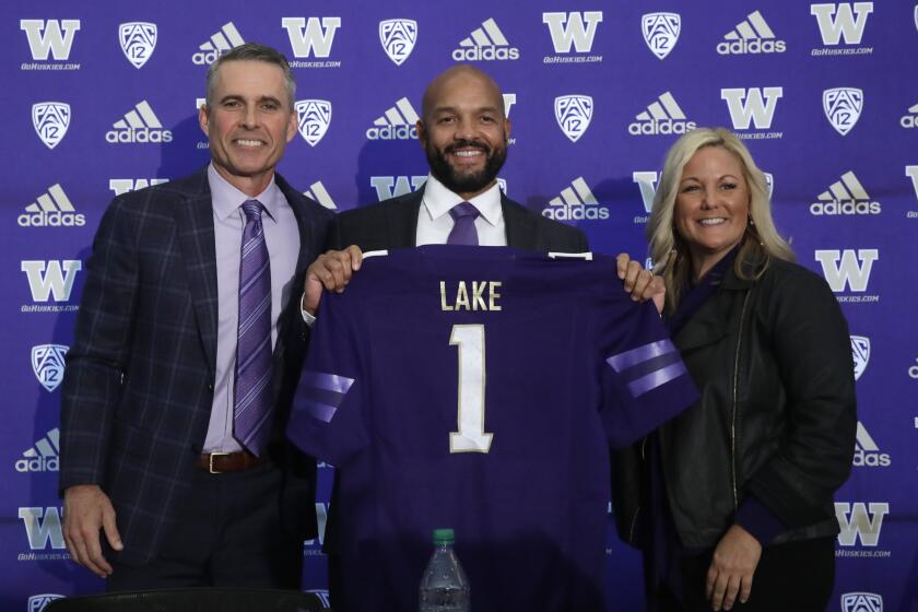 Washington football head coach Chris Petersen, left, poses for a photo with defensive coordinator Jimmy Lake and athletic director Jen Cohen after a news conference about Petersen's decision to resign and Lake taking over his job, Tuesday, Dec. 3, 2019, in Seattle. Petersen unexpectedly resigned at Washington on Monday, a shocking announcement with the Huskies coming off a 7-5 regular season and bound for a sixth straight bowl game under his leadership. Petersen will coach Washington in a bowl game, his final game in charge. (AP Photo/Elaine Thompson)