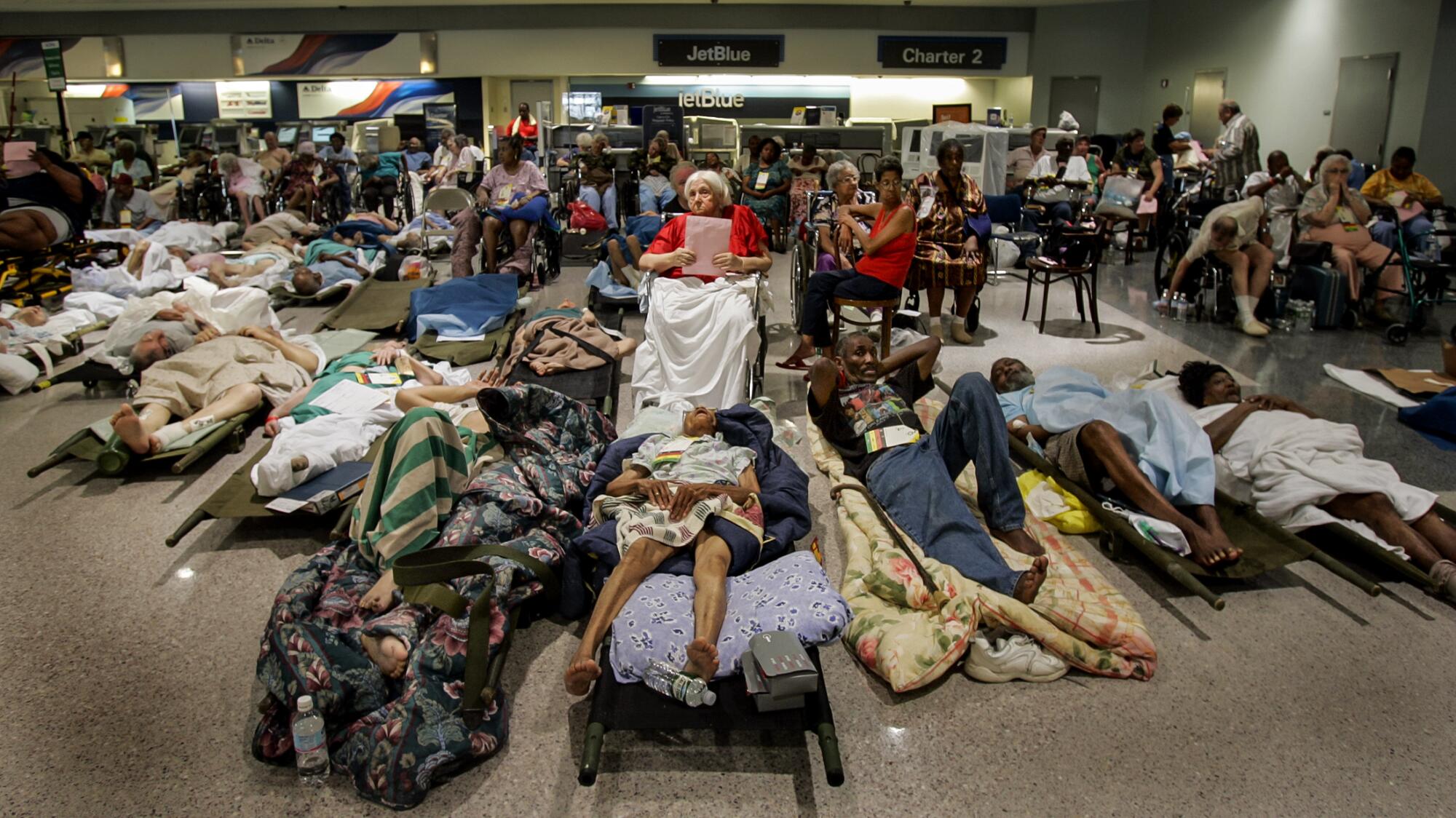 Evacuating hospital patients wait on stretchers and in wheelchairs