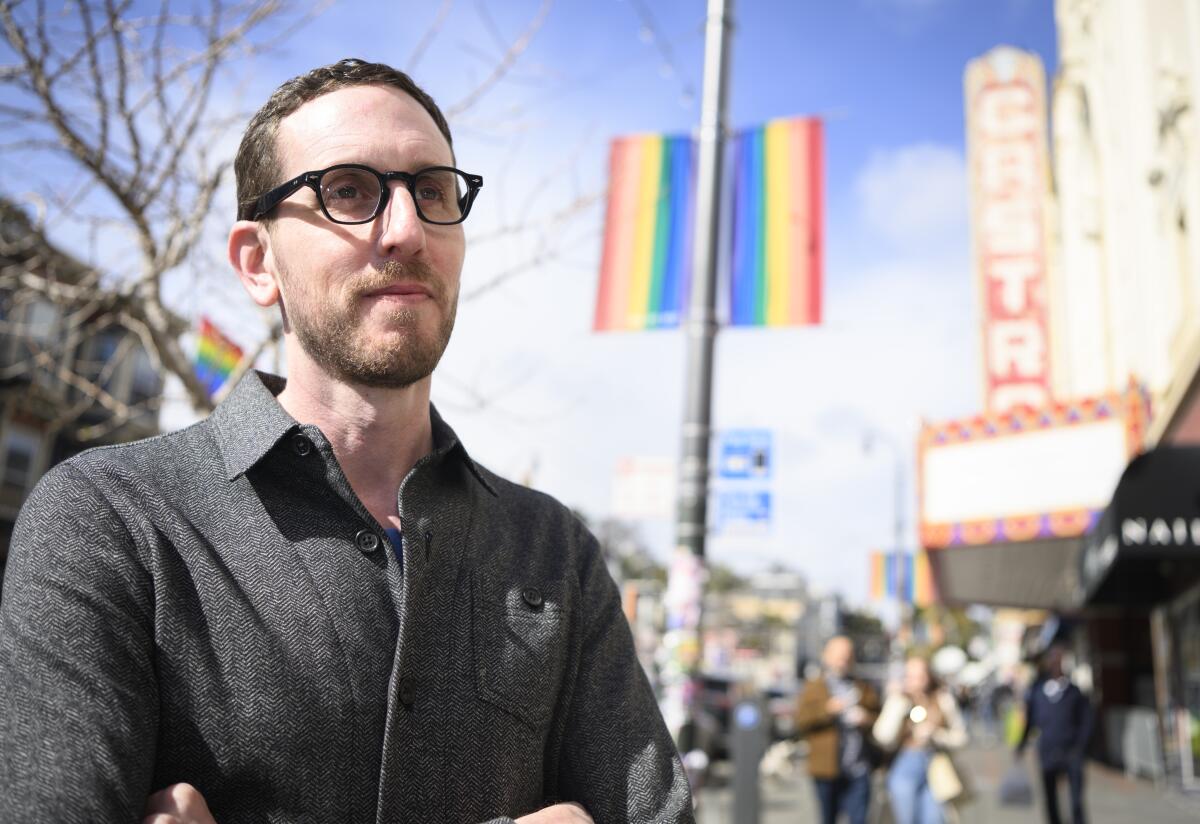 California state Sen. Scott Wiener stands in the Castro district of San Francisco, with a rainbow flag in the background