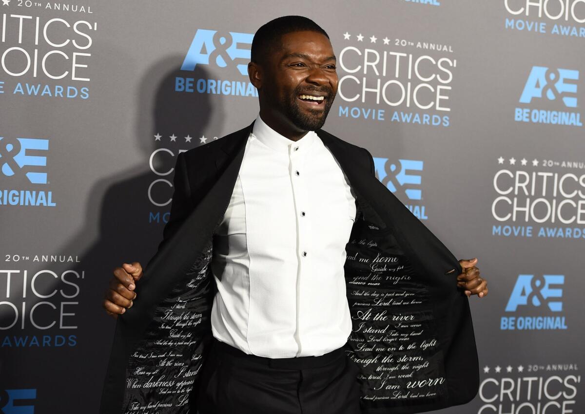 David Oyelowo shows off the embroidered lining of his tuxedo -- which pays homage to the Rev. Martin Luther King Jr. -- during his arrival at the 20th annual Critics' Choice Movie Awards at the Hollywood Palladium in Los Angeles.