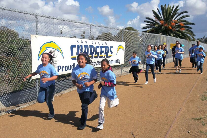 Laurel Elementary students Jessica Morales, (from left) Leslie Alaniz, and Samantha Benjamin run on their new track after its dedication Tuesday. The Chargers Champions Grant Program donated $30,000 for the track.