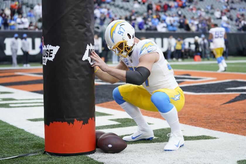 Los Angeles Chargers' Joey Bosa (97) stretches before an NFL football game between the Cincinnati Bengals and the Los Angeles Chargers, Sunday, Dec. 5, 2021, in Cincinnati. (AP Photo/Michael Conroy)