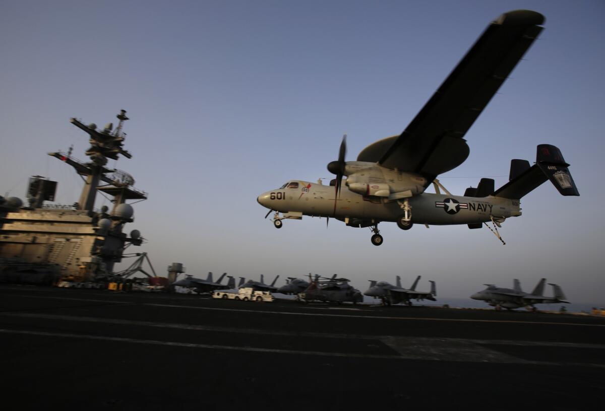 In this Aug. 10, 2014, file photo, an aircraft lands after missions targeting the Islamic State group in Iraq from the deck of the U.S. Navy aircraft carrier USS George H.W. Bush in the Persian Gulf.
