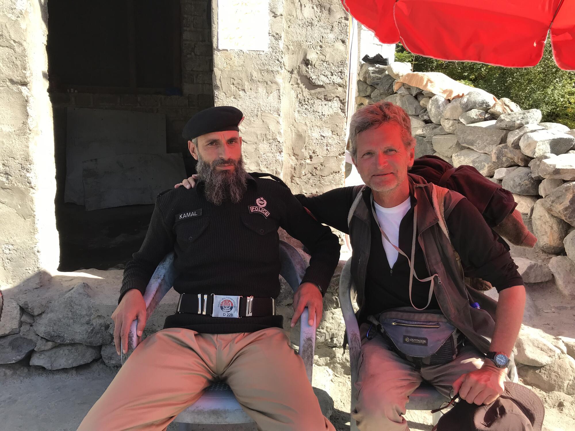 Paul Salopek with a bearded cop at a checkpoint in northern Pakistan.