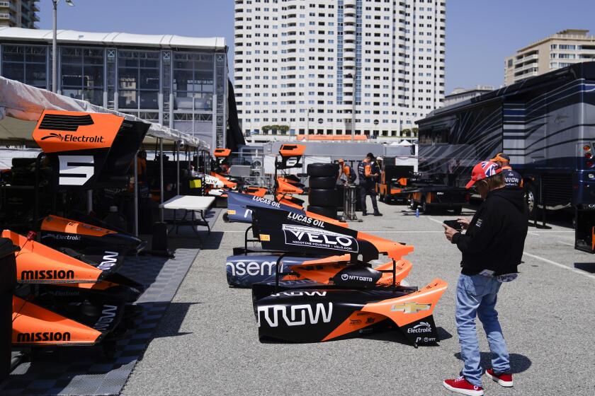 A man takes photos of the shell of Arrow McLaren SP driver Pato O'Ward's vehicle after a qualifying session for the IndyCar Grand Prix of Long Beach auto race Saturday, April 20, 2024, in Long Beach, Calif. (AP Photo/Ryan Sun)