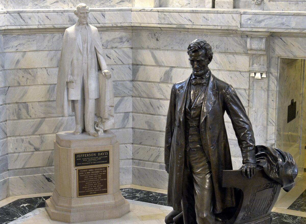 A statue of Jefferson Davis, left, faces a statue of Abraham Lincoln in the Rotunda of the state Capitol in Frankfort, Ky.