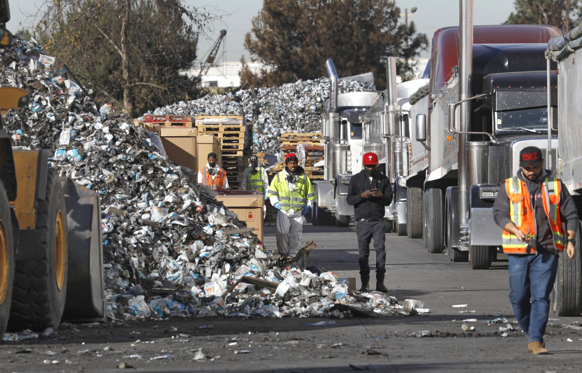 Workers hired to clean millions of pounds of charred hand sanitizer products from a warehouse fire in Carson on Sept. 30