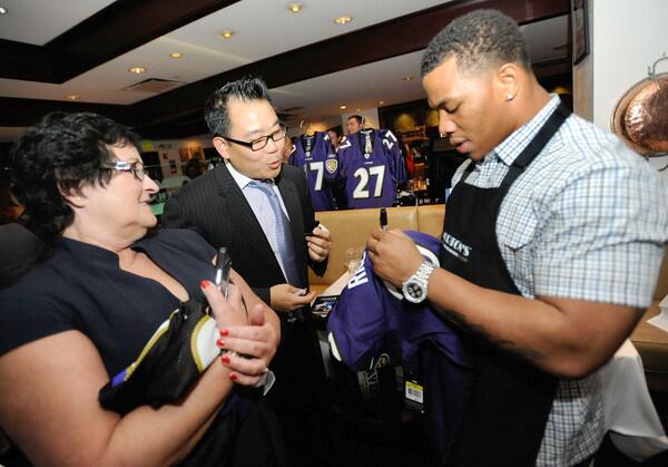 Ray Rice, right, of the Baltimore Ravens signs autographs for Elaine Moffett, left, of New Freedom, Pa. and Charley Sung, center, of Columbia at Morton's The Steakhouse during Matt Birk and Friends Celebrity Server Night to benefit Matt Birk's HIKE Foundation.