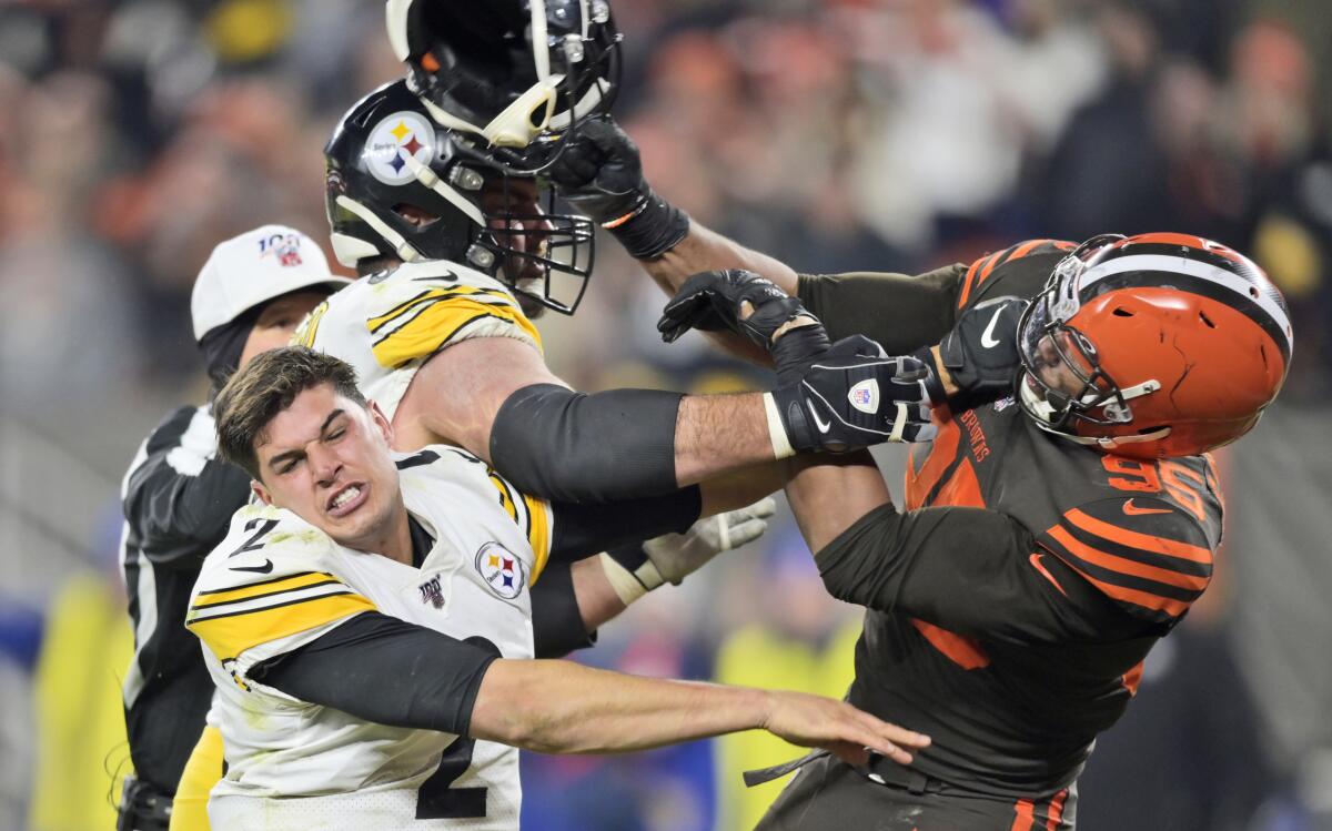 Myles Garrett, defensive end de los Browns de Cleveland, golpea con un casco a Mason Rudolph, quarterback de los Steelers de Pittsburgh, durante el partido dle jueves 14 de noviembre de 2019 .