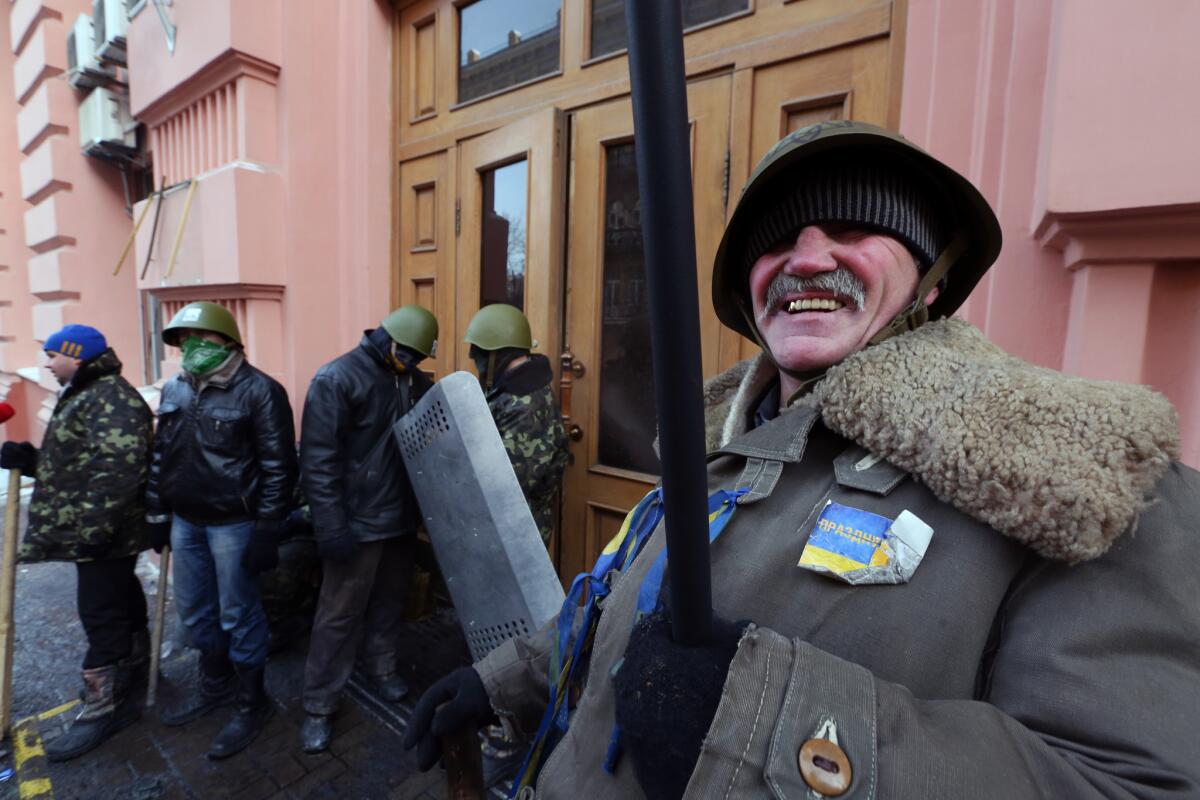Opposition protesters stand outside a Justice Ministry building in central Kiev, Ukraine, after having captured it late Saturday.