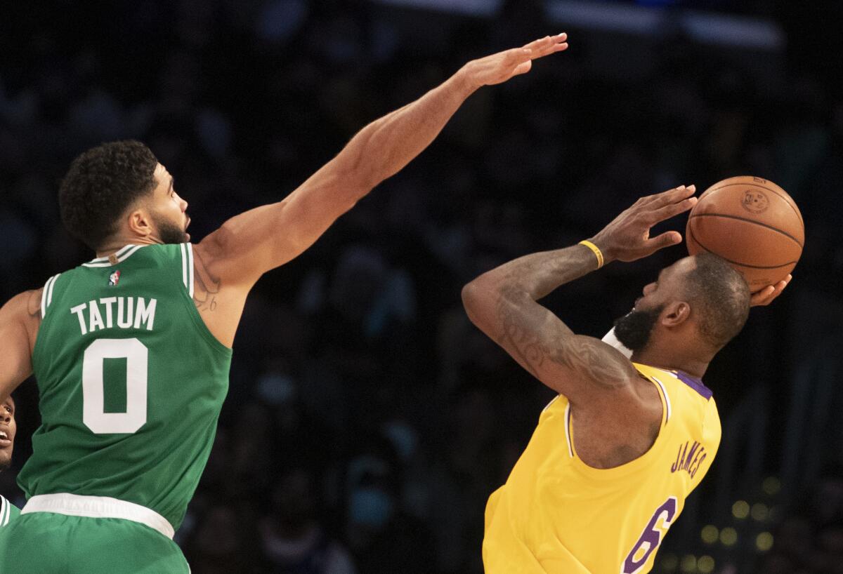 Lakers forward LeBron James attempts a shot over Celtics forward Jayson Tatum.