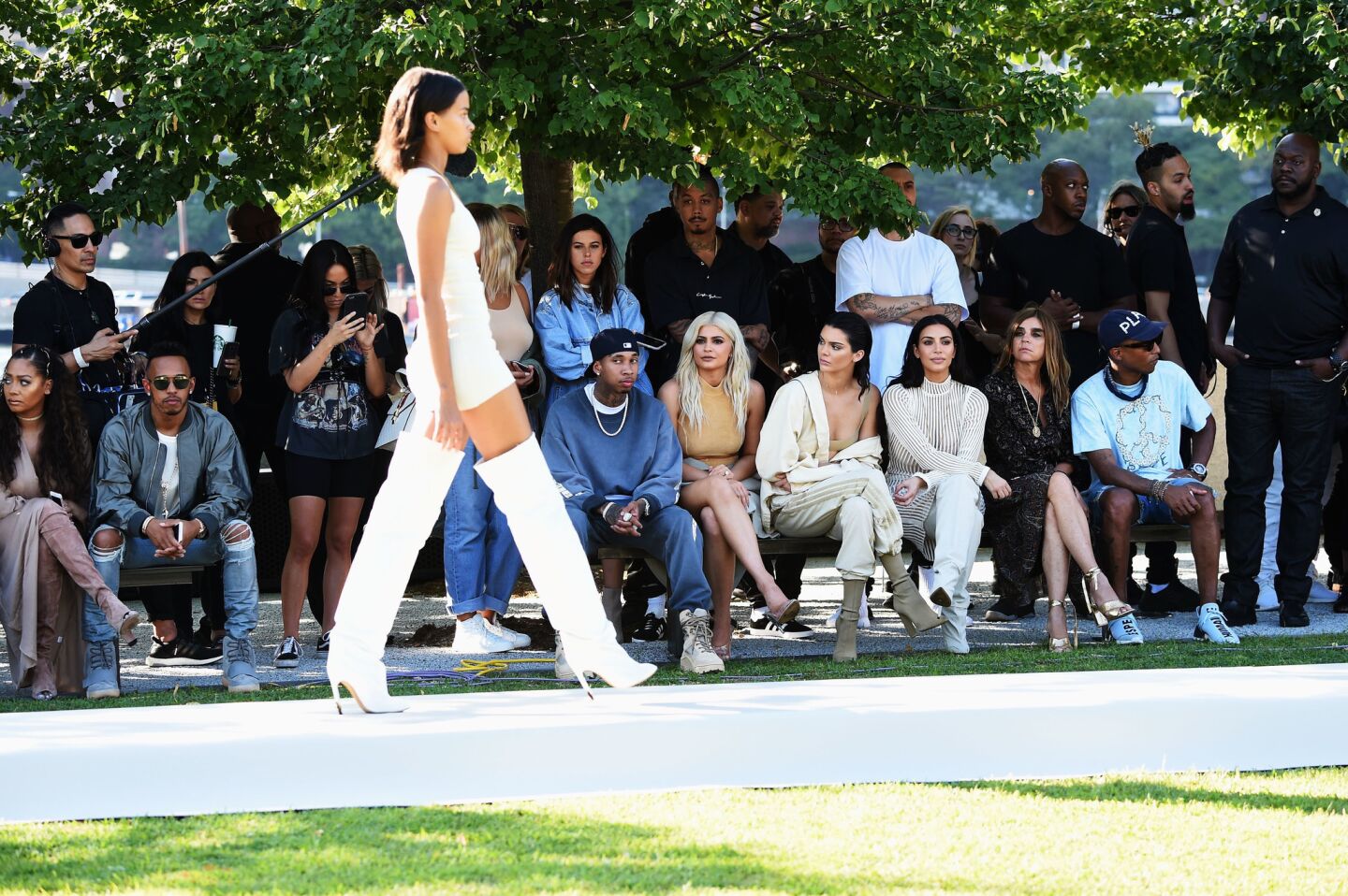 Tyga, left, Kylie Jenner, Kendall Jenner, Kim Kardashian, Carine Roitfeld and Pharrell Williams attend the Kanye West Yeezy Season 4 fashion show.