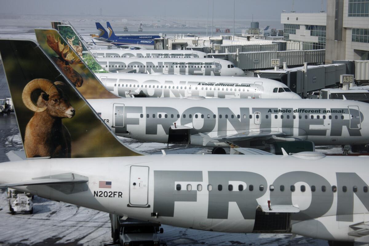 Frontier Airlines jetliners sit stacked up at gates at Denver International Airport. The carrier plans to raise some bag fees starting May 1.