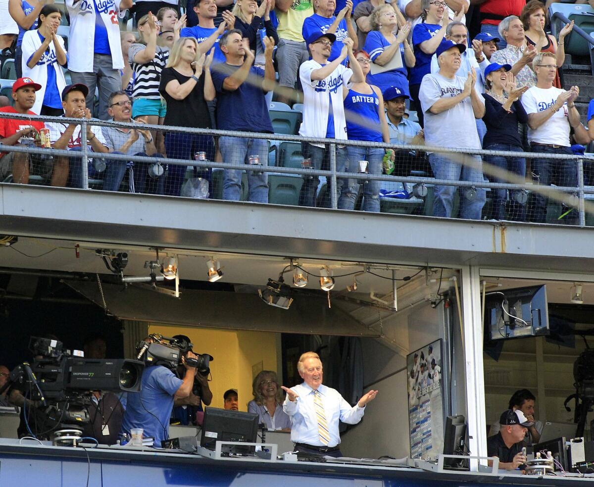 Dodgers announcer Vin Scully acknowledges the crowd after it was announced that Tuesday he would come back for another season.