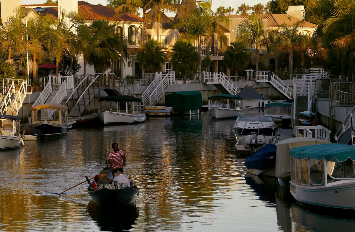 A gondolier rows visitors through the canals of Naples, a bayside community in Long Beach.
