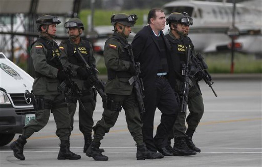 Colombian police officers escort alleged drug trafficker Walid “The Turk” Makled to a waiting plane at the military airport in Bogota, Colombia, Monday May 9, 2011. The Venezuelan citizen of Syrian descent was arrested late last year on a U.S. warrant in Colombia. Colombia President Juan Manuel Santos said the law favored Makled being sent to Venezuela instead of the U.S. because it was the first country to request his extradition.(AP Photo/Fernando Vergara)
