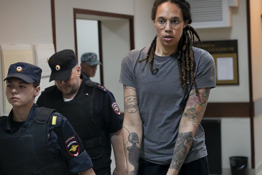 FILE - WNBA star and two-time Olympic gold medalist Brittney Griner is escorted from a court room ater a hearing, in Khimki just outside Moscow, Russia, Aug. 4, 2022. (AP Photo/Alexander Zemlianichenko, File)