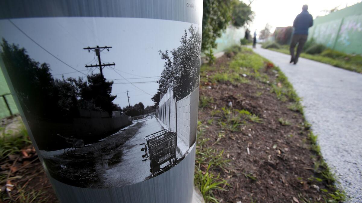 A picture on a sign post shows previous drainage problems at the end of the 7700 block of Elmer Street in Sun Valley, an area prone to street flooding in stormy weather. The street has been outfitted with natural swales and drains to help alleviate pooling water.