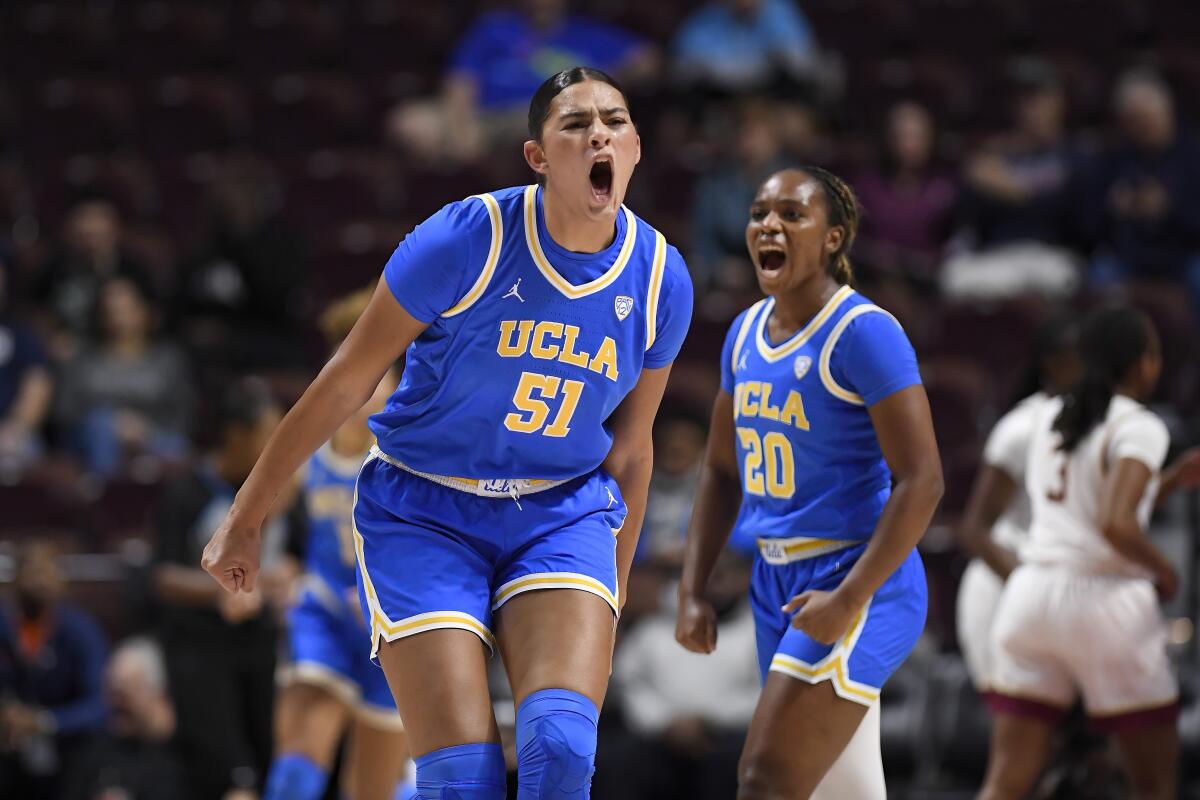 UCLA center Lauren Betts (51) and guard Charisma Osborne (20) let out yells as they react to a play.