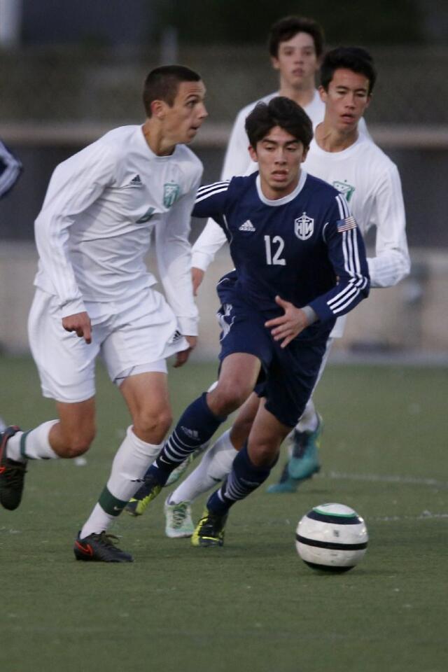 Edison's Kobe Wood and Newport Harbor's Alex Avila battle for the ball in a Sunset League soccer game.