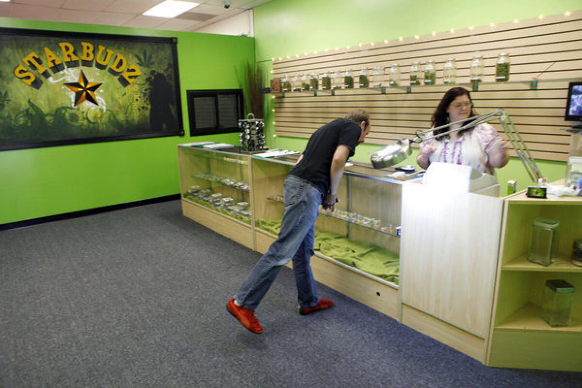 In this May 5, 2010, photo, "budista" Angela Nagel assists a client at the Starbudz medical marijuana dispensary in North Hollywood. California cities and counties can ban the shops, the state's highest court ruled Monday.